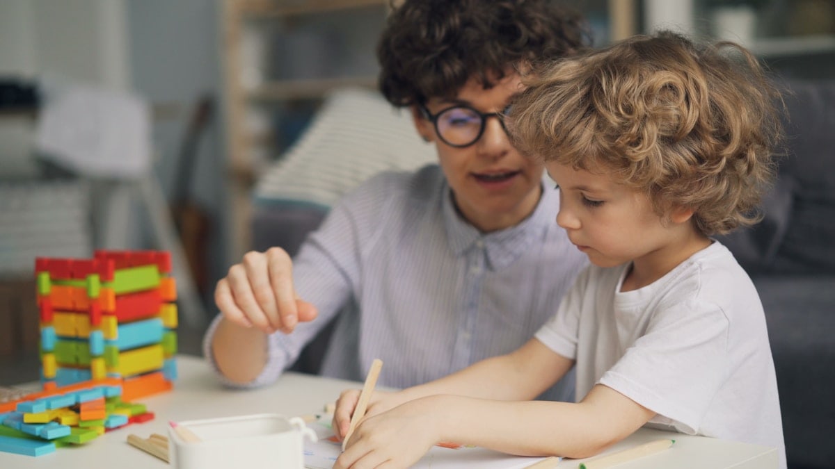 a man and a child are playing with blocks